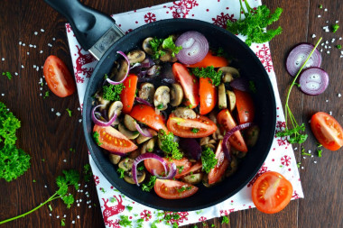 Mushrooms with tomatoes fried in a pan