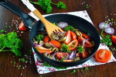 Mushrooms with tomatoes fried in a pan