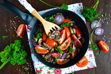 Mushrooms with tomatoes fried in a pan