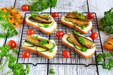 Sandwiches with sprats and cucumber on a loaf