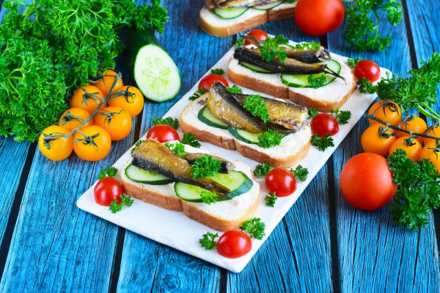 Sandwiches with sprats and cucumber on a loaf