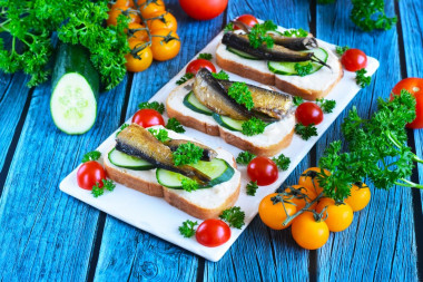 Sandwiches with sprats and cucumber on a loaf