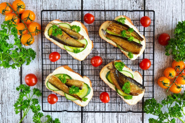 Sandwiches with sprats and cucumber on a loaf