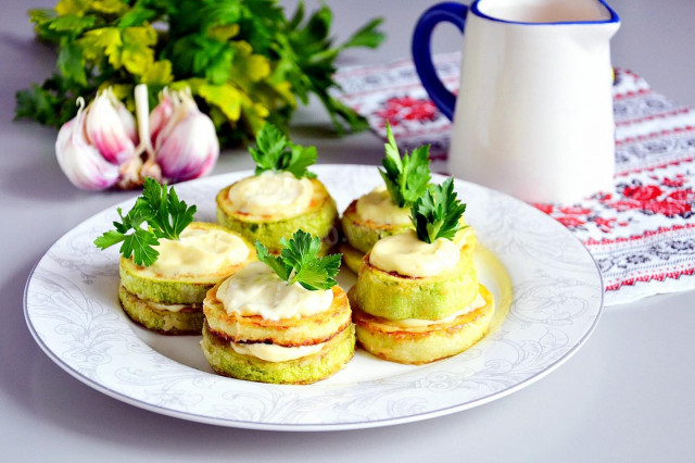 Fried zucchini in a pan with garlic and mayonnaise