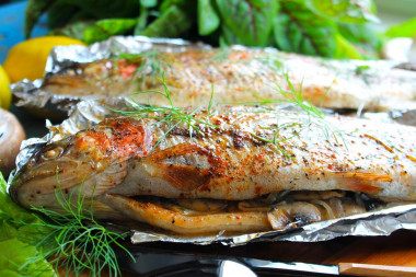 Trout in foil on coals on a grill