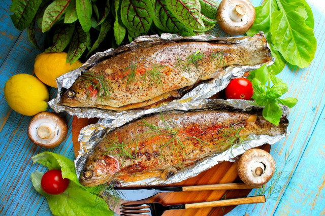 Trout in foil on coals on a grill