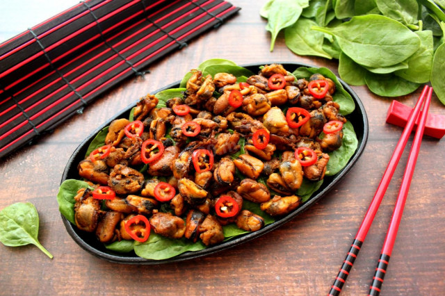 Fried mussels with garlic and soy sauce in a frying pan