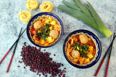 Asian soup with meatballs noodles and beans