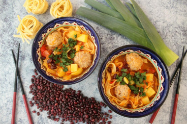 Asian soup with meatballs noodles and beans