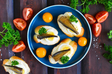 Sandwiches with sprats, melted cheese and egg