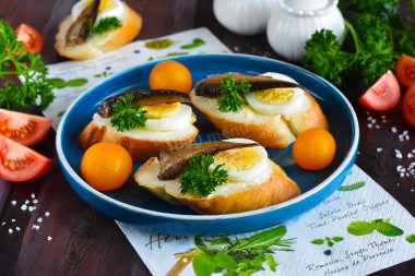 Sandwiches with sprats, melted cheese and egg