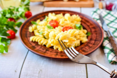 Macaroni with cheese and egg in a frying pan