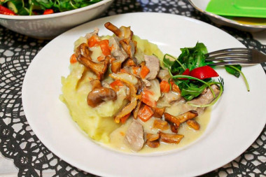 Meat in cream sauce with mushrooms in a frying pan