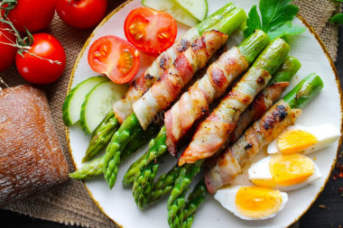 Green asparagus with bacon in a frying pan