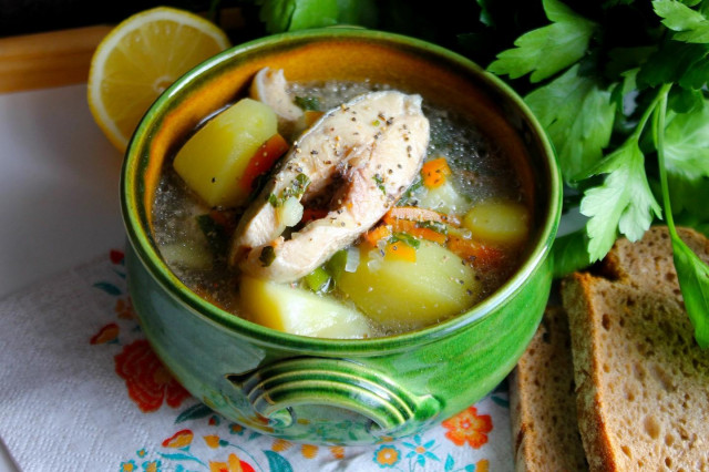 Trout soup in a cauldron over a campfire