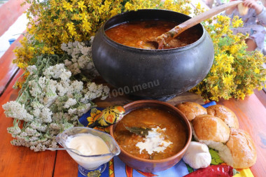 Stewed borscht in a cauldron with zucchini and apples