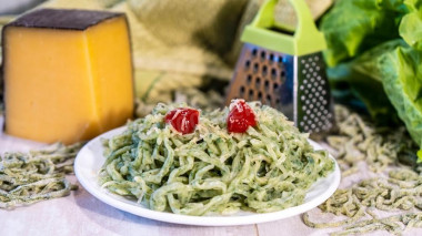 Homemade noodles with chicken egg, spinach and hard cheese