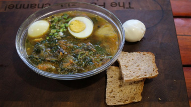 Spring cabbage soup, lean nettle and sorrel in a cauldron over a fire