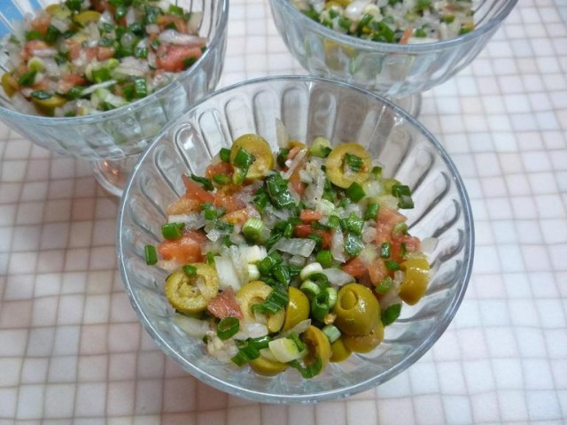 Pollock liver salad with tomatoes, olives and onions