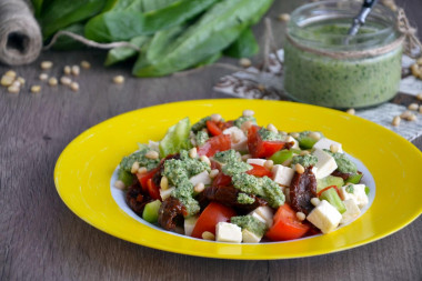 Salad with cheese and dried tomatoes with spinach sauce