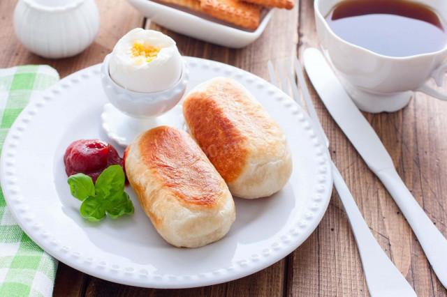 Sausages in yeast dough fried in a frying pan