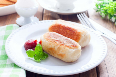 Sausages in yeast dough fried in a frying pan