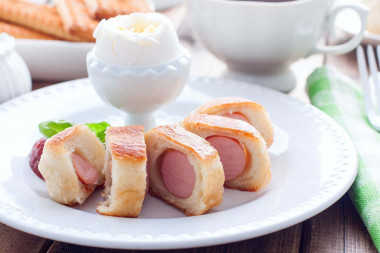 Sausages in yeast dough fried in a frying pan