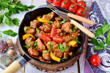 Pork fried in pieces in a pan with onions