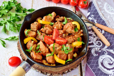 Pork fried in pieces in a pan with onions