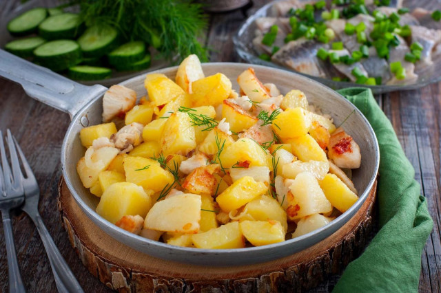 Fried potatoes with chicken fillet in a frying pan