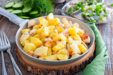 Fried potatoes with chicken fillet in a frying pan