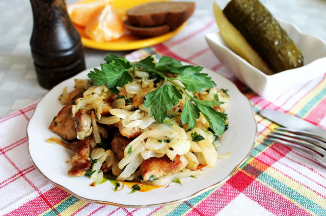 Fried cabbage with meat in a frying pan