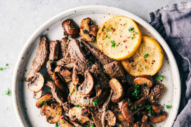 Fried meat with mushrooms in a frying pan