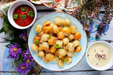 Fried dumplings with onions in a frying pan