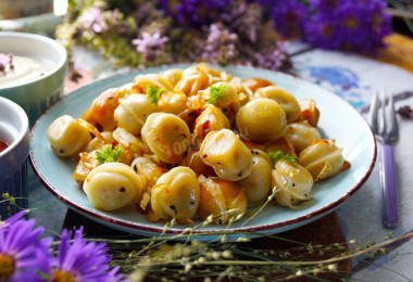 Fried dumplings with onions in a frying pan