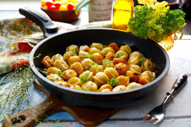 Fried dumplings with onions in a frying pan