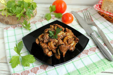 Fried chicken liver in flour with onions in a frying pan