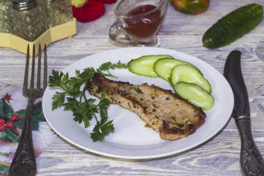 Roast pork loin on a bone in a frying pan