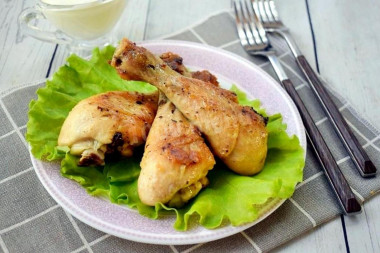 Chicken legs fried with dry spices in a frying pan