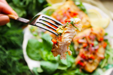 Pangasius on a grill pan with fried vegetables