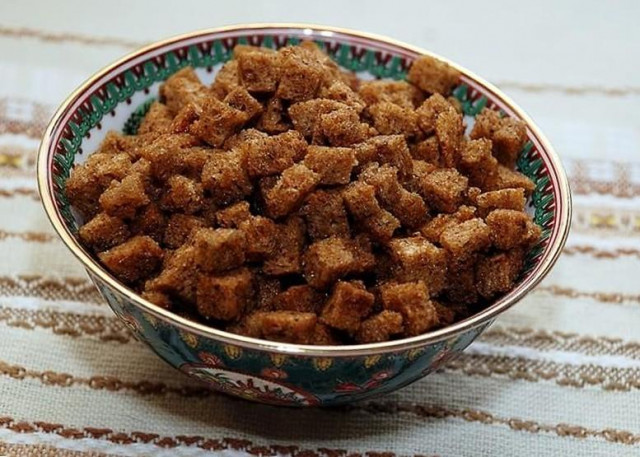 Fried black bread crackers with garlic in a frying pan