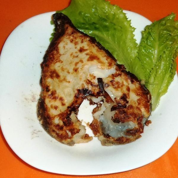 Fried catfish breaded in flour in a frying pan