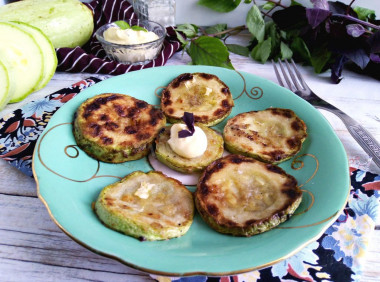 Zucchini fried in flour in a frying pan