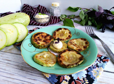 Zucchini fried in flour in a frying pan