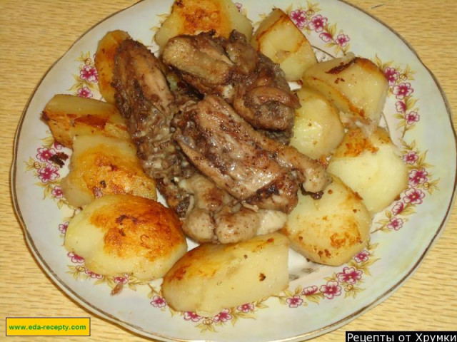 Fried chicken in a pan with potatoes