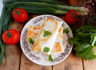 Pita bread in a frying pan with cheese