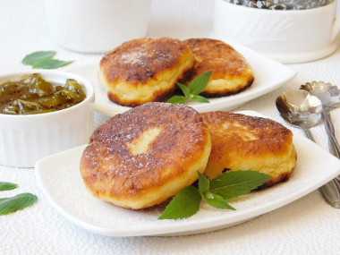 Fluffy cottage cheese pancakes with flour in a frying pan