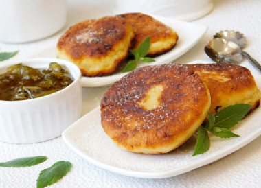 Fluffy cottage cheese pancakes with flour in a frying pan