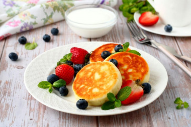 Cottage cheese pancakes with flour in a frying pan