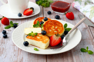 Cottage cheese pancakes with flour in a frying pan